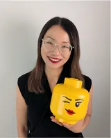 Hayley Hsieh, ICF ACC coach and Serious Play Strategist, holding a large winking LEGO minifigure head